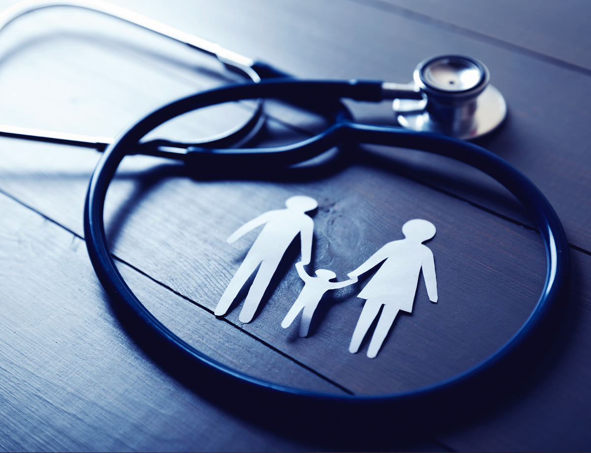 an image of a stethoscope with a paper cutout of a man and woman holding the hands of a child