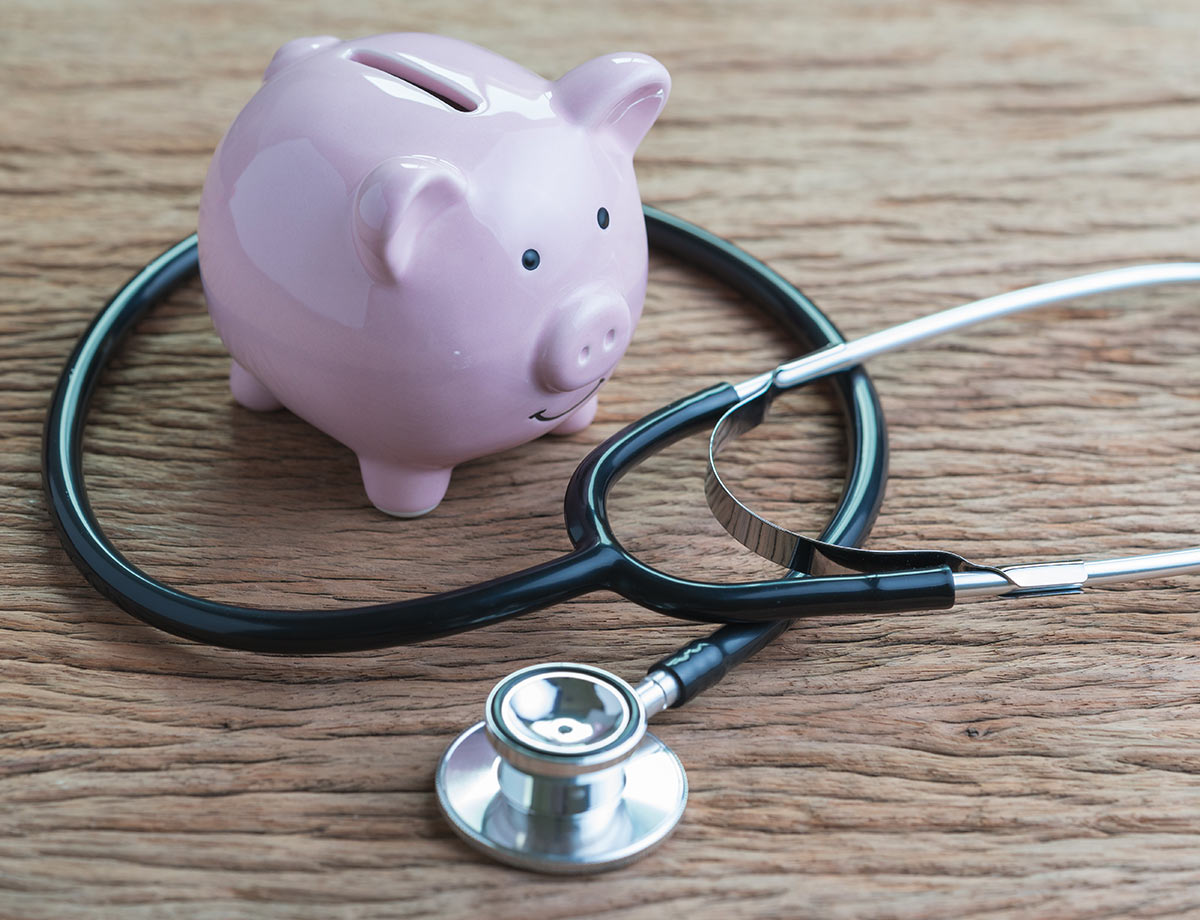 a piggy bank on a desk with a stethoscope wrapped around it